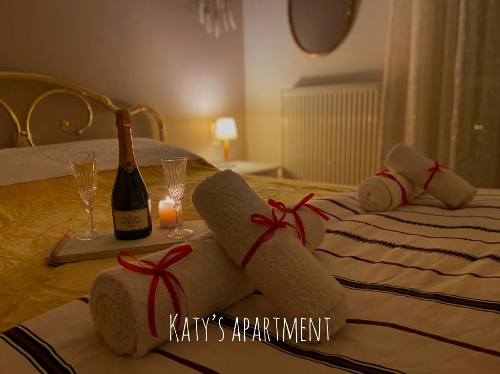 uma cama com uma garrafa de champanhe e duas toalhas em Katy's apartment em Patra