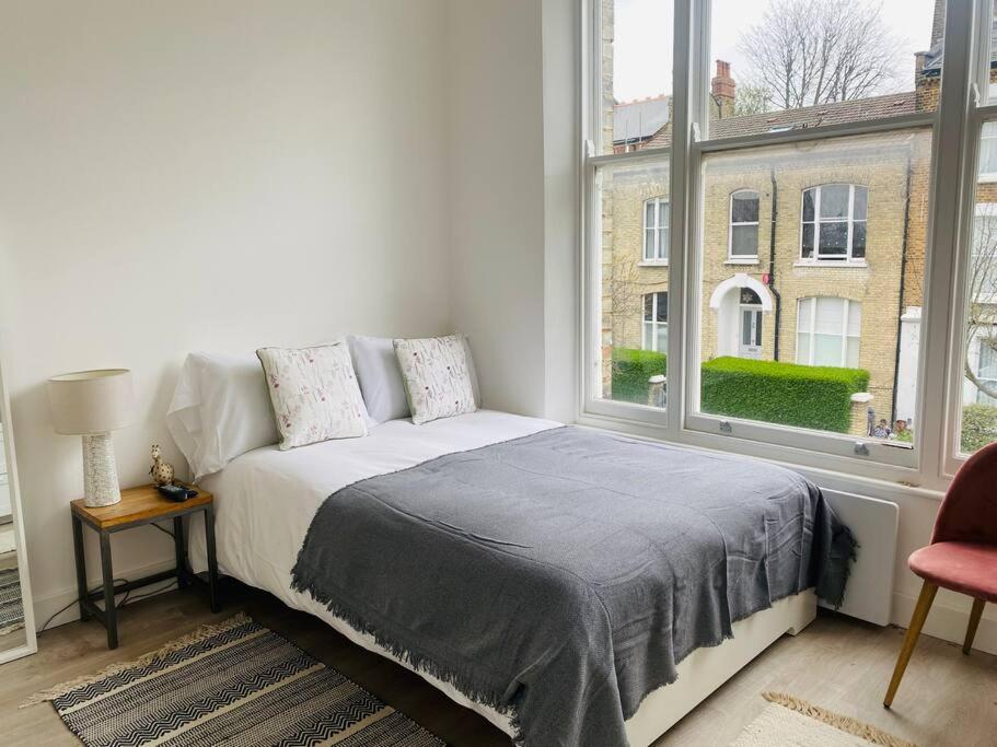 a bedroom with a bed and a large window at Studio close to Camden in London