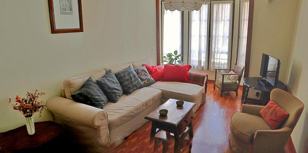 sala de estar con sofá y TV en La Marina, en Gijón