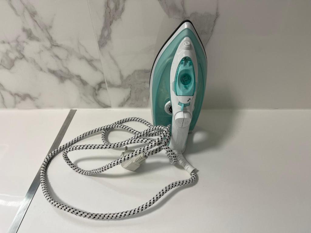 a green hairdryer with a rope attached to it at Appartement Prestige - Amiens in Amiens