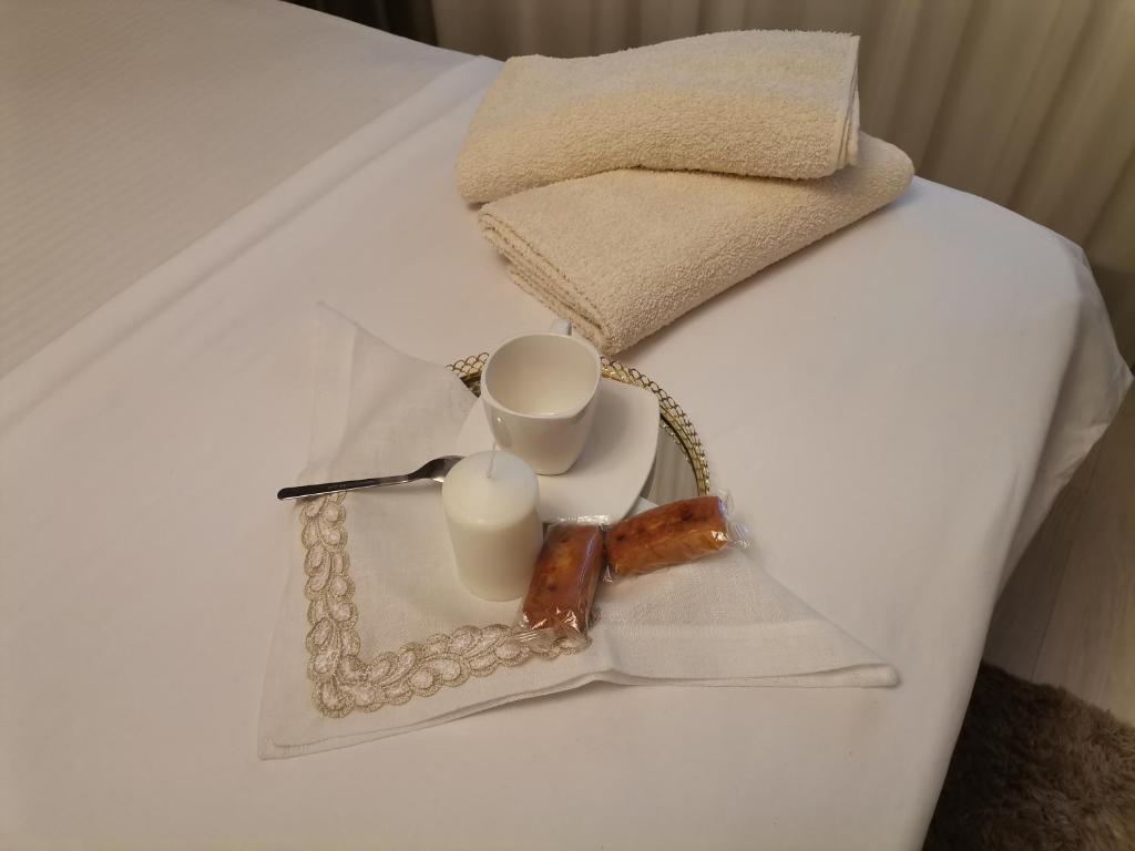 ein Tablett mit zwei Tassen und Kerzen auf einem Bett in der Unterkunft Unirii Apartament 2 in Bukarest