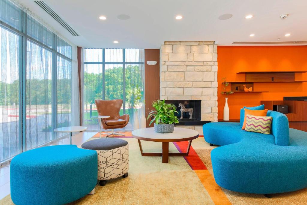 a living room with blue chairs and a fireplace at Fairfield Inn & Suites by Marriott Decatur at Decatur Conference Center in Decatur