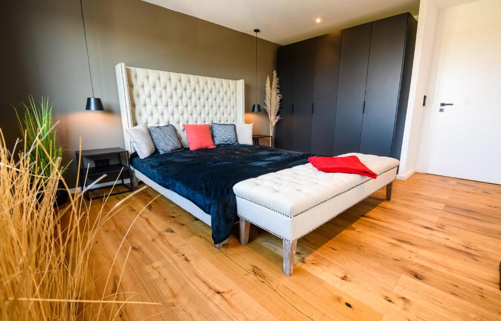 プリーン・アム・キームゼーにあるOrangeHome Design Apartment zwischen See & Zentrumのベッドルーム1室(キングサイズベッド1台、青と赤の枕付)