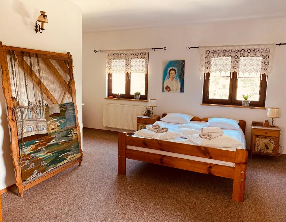 a bedroom with a large bed with white sheets at Restauracja Pensjonat Buda in Krosno