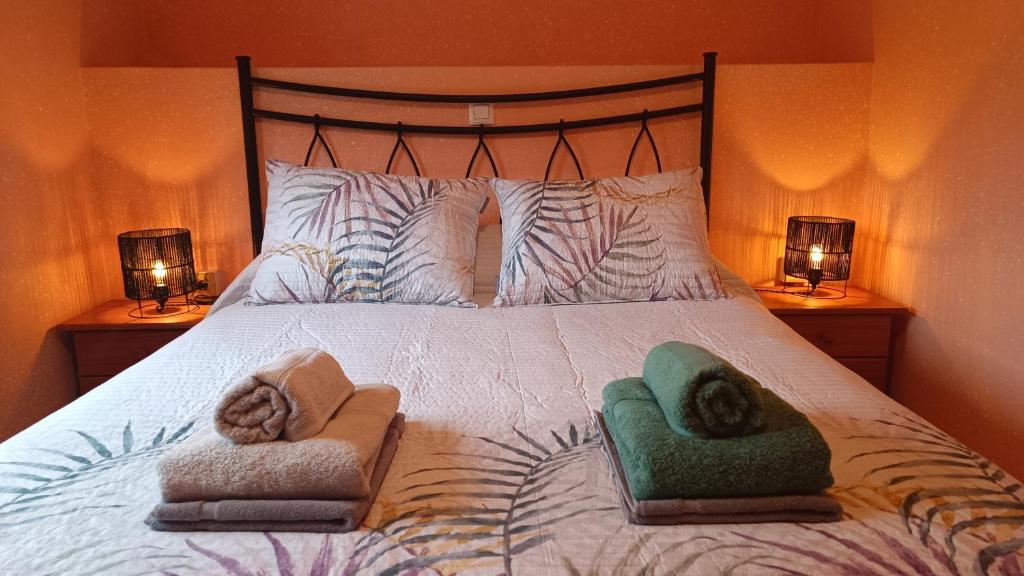 a bedroom with a large bed with two towels on it at Casa Millar. in Huergas y El Millar