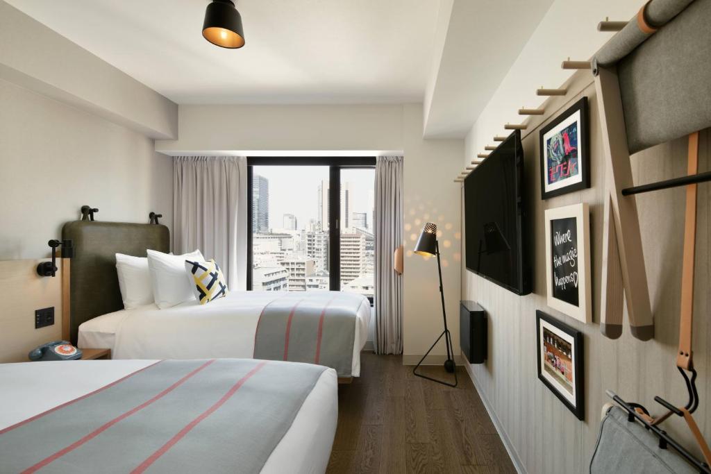 Postel nebo postele na pokoji v ubytování Moxy Osaka Umeda