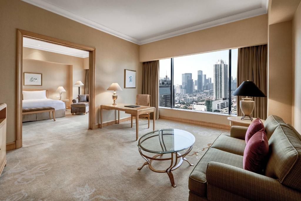 a hotel room with a couch and a bed and a window at JW Marriott Hotel Jakarta in Jakarta