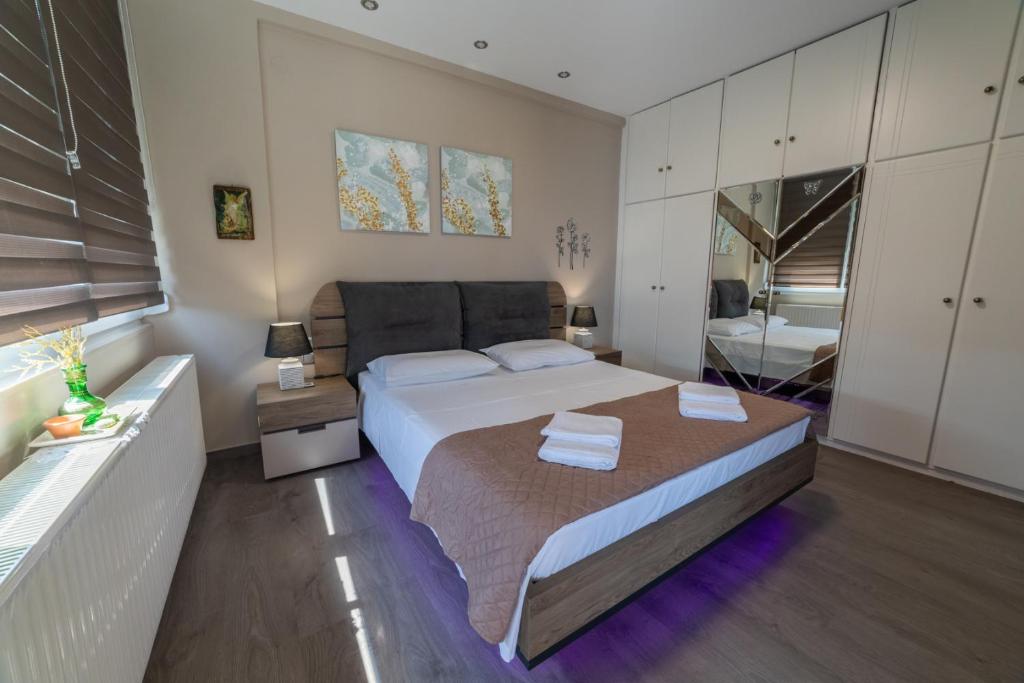 sypialnia z dużym łóżkiem z dwoma ręcznikami w obiekcie Seaside Serenity w mieście Wolos