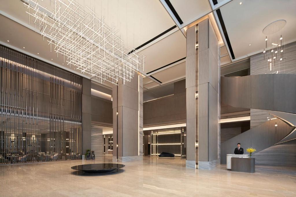 a lobby with a man sitting at a desk in a building at Wenzhou Marriott Hotel in Wenzhou