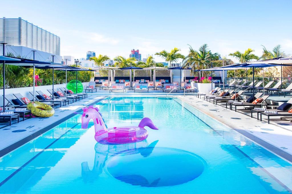 a swimming pool with a pink duck in the water at Moxy Miami South Beach in Miami Beach