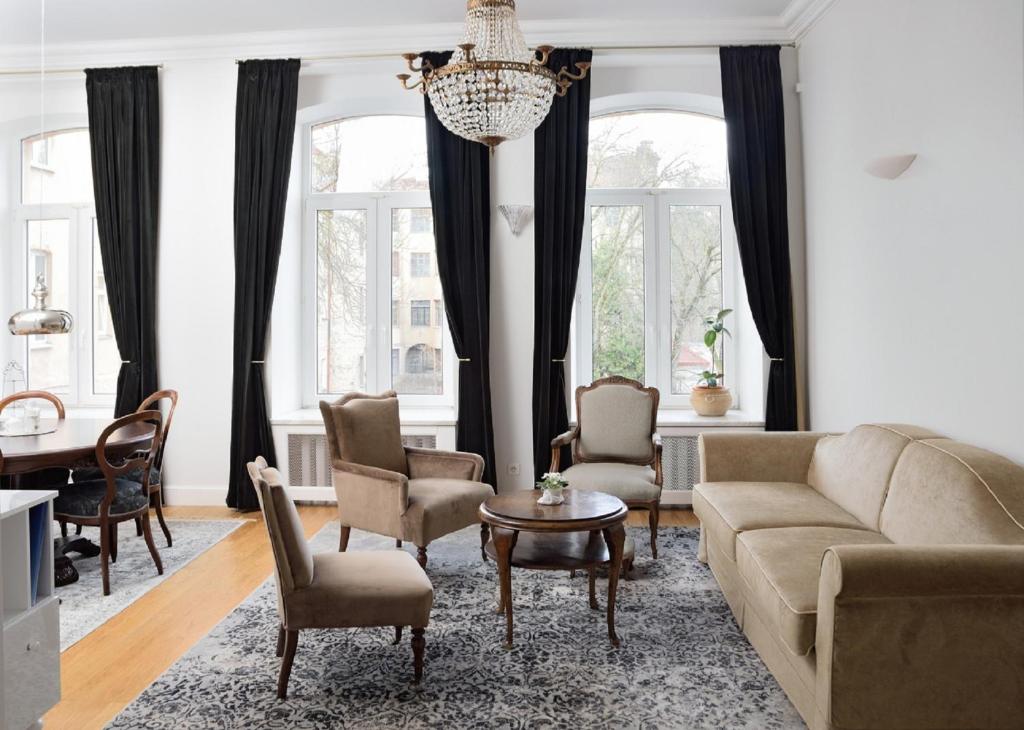 a living room with a couch and chairs and a piano at Cosy Old Vilnius in Vilnius