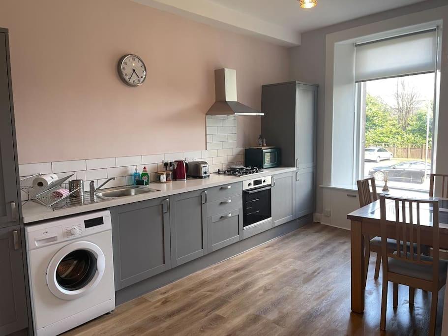 a kitchen with a sink and a washing machine at Newly Renovated Ground Floor 1-Bed Flat in Bonhill