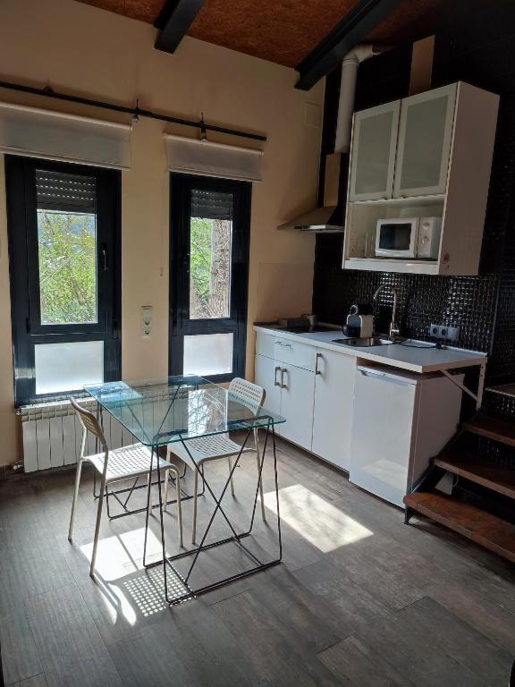 a kitchen with a glass table and chairs in it at la casa de las cabilas in Cuevas del Valle