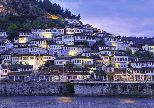 un grupo de casas blancas en una colina cerca del agua en Guesthouse Family Doko, en Berat