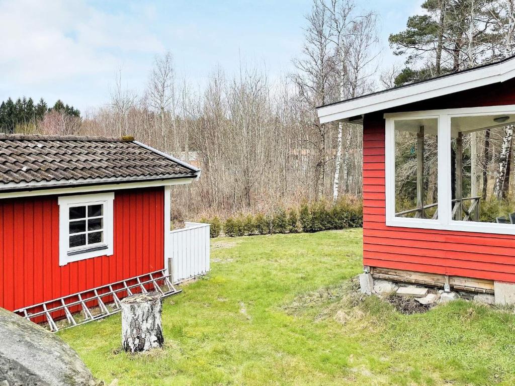 een rood huis naast een klein huis bij Holiday home HAKENÄSET IV in Balkeröd