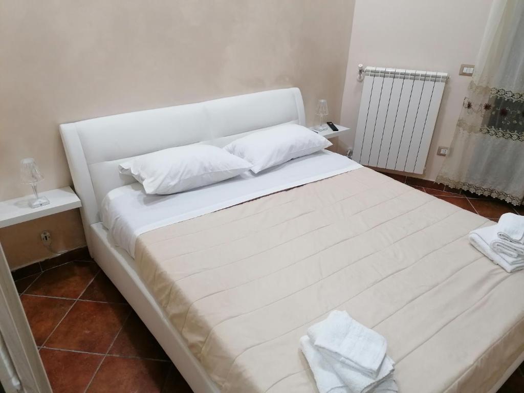 een groot wit bed met 2 kussens erop bij CaSa AMELIA in Napels