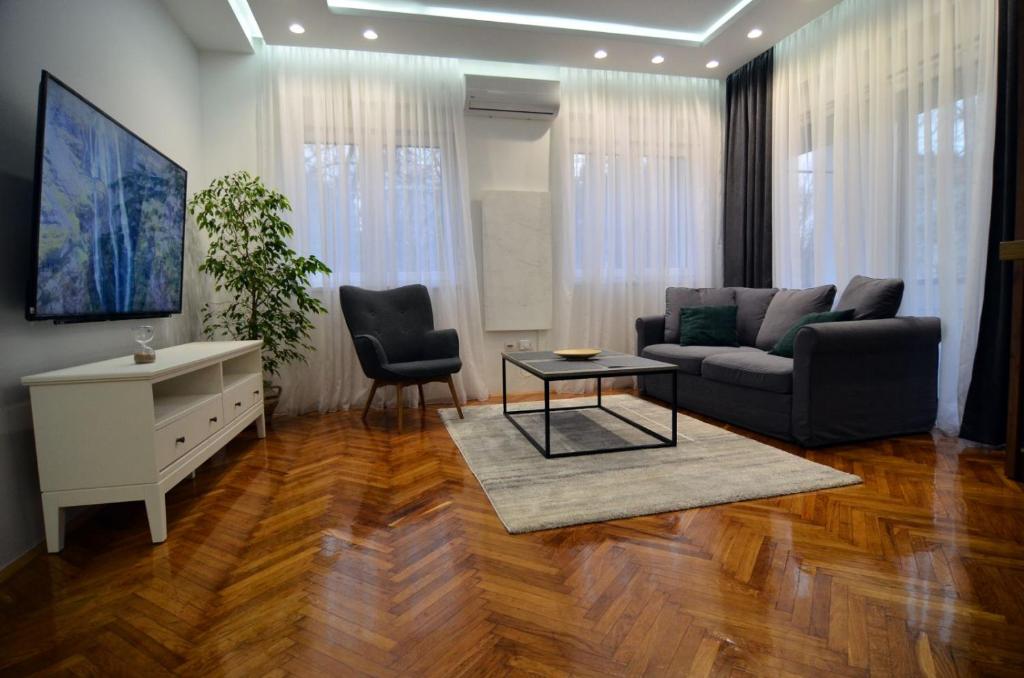 een woonkamer met een bank en een tafel bij Honey 1 Apartmani Loznica in Loznica
