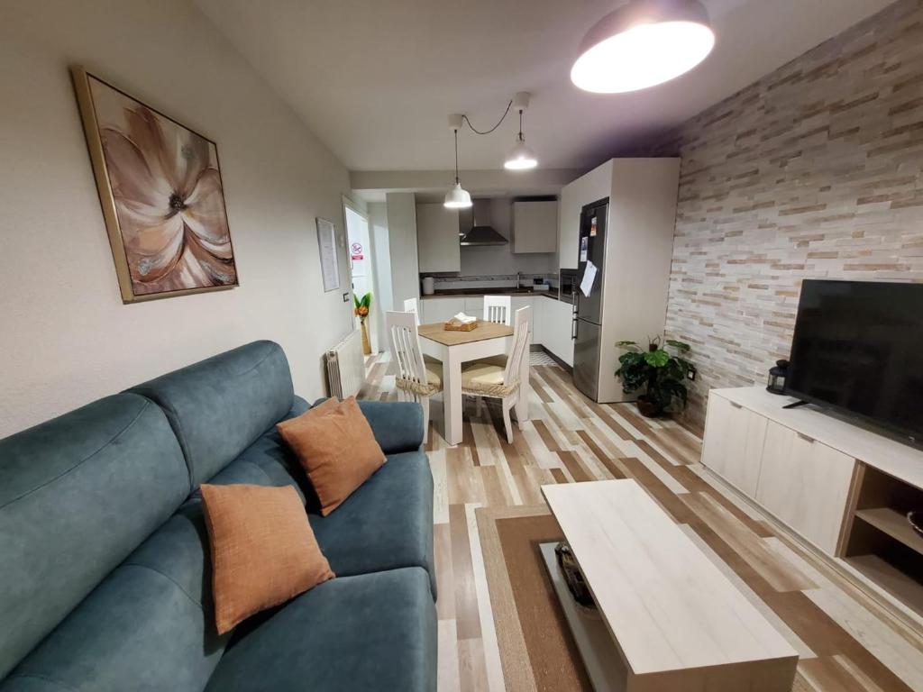un soggiorno con divano blu e tavolo di Alojamiento en Villamayor a Villamayor