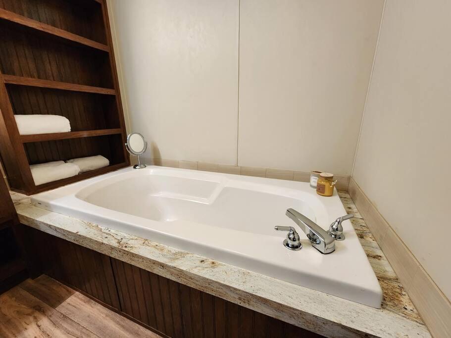 a bathroom with a large white tub with a mirror at River Dreams Cabins & Glamping in Concan