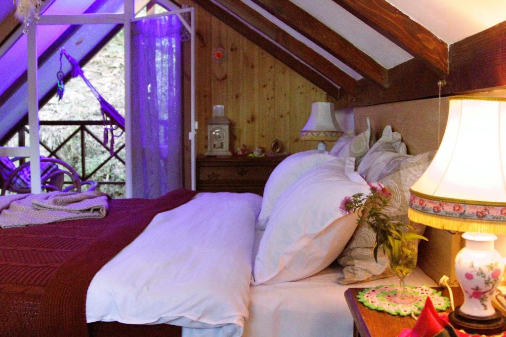 1 dormitorio con 1 cama y 1 mesa con lámpara en budabu, en Signagi