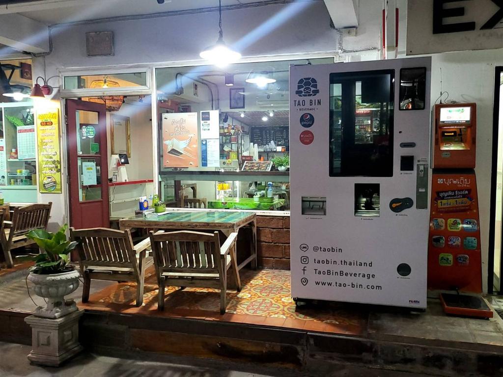 ein Restaurant mit einem Tisch und einem Verkaufsautomaten in der Unterkunft Ratanawong Place 552 in Bangkok