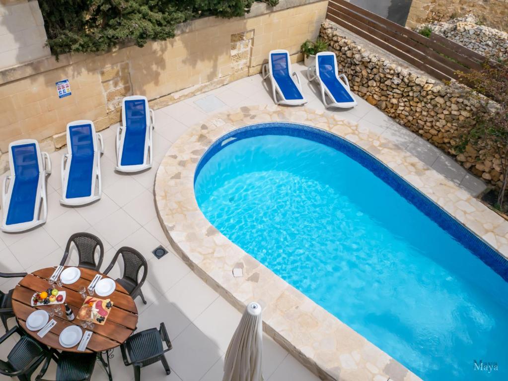 uma vista superior de uma mesa e cadeiras ao lado de uma piscina em Il Gnejna em Xaghra