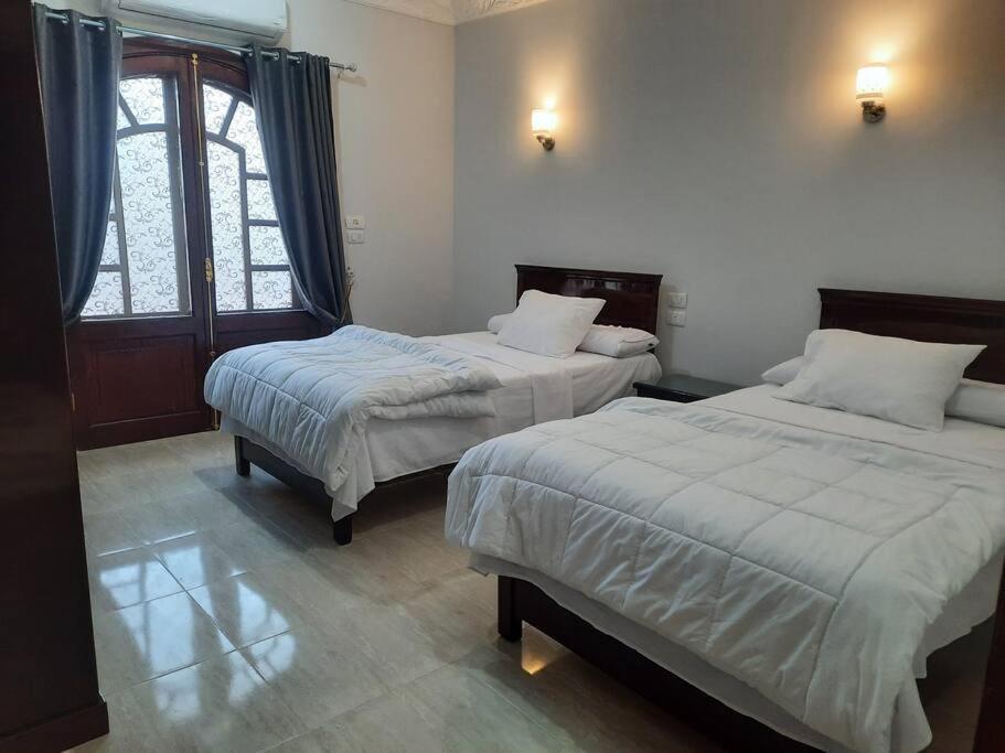 The royal flat for rent في Al Qurnah: غرفة نوم بسريرين ونافذة