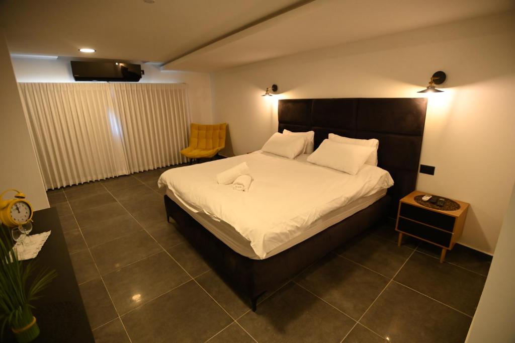 ein Schlafzimmer mit einem großen Bett mit weißer Bettwäsche und Kissen in der Unterkunft Puy Castele Hotel Tiberias in Tiberias