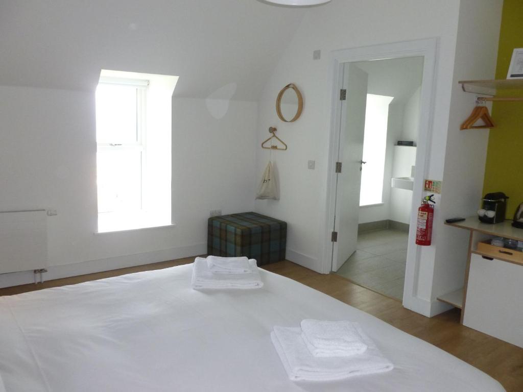 a white room with two white towels on a bed at Buckie - 1 Bedroom with ensuite in Wick