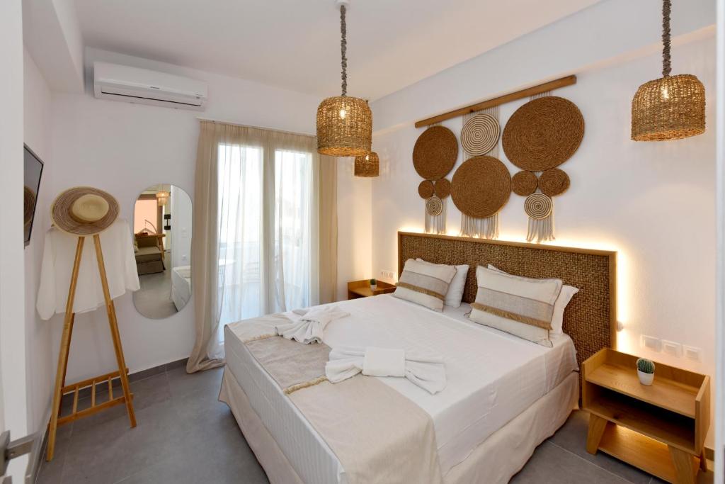 ein Schlafzimmer mit einem großen weißen Bett und einem Spiegel in der Unterkunft Kryni Deluxe Houses in Adamas