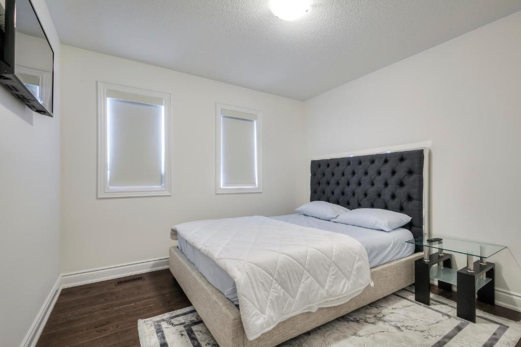 a white bedroom with a bed and two windows at Masterfully Designed Private Suite in Bradford