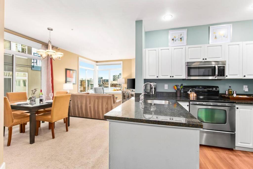 a kitchen and living room with a table and chairs at Corner Unit in the middle of it all - 99 Walkscore in Seattle