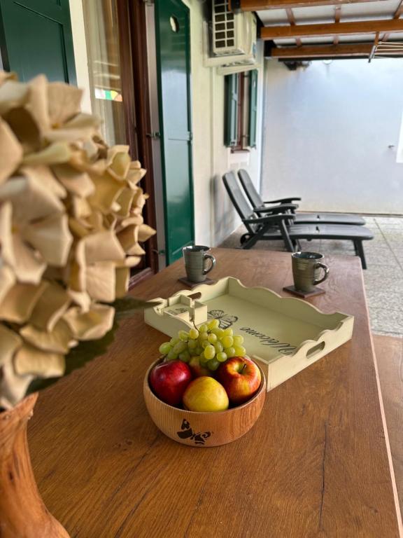 un bol de fruta en una mesa con una caja de manzanas en Apartment Butterfly, en Čatež ob Savi