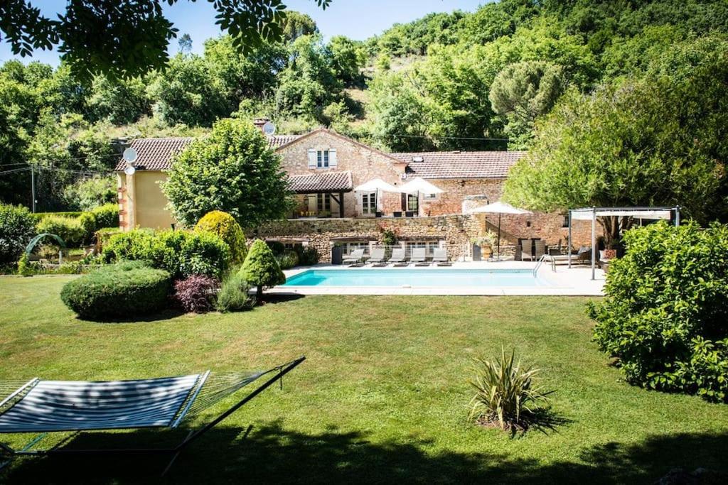 een huis met een zwembad in een tuin bij Beautiful Home with Large Gardens and Heated Pool in Sauveterre-la-Lémance