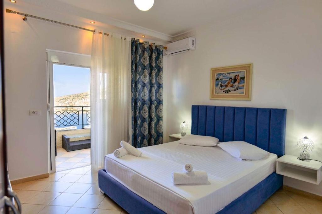 1 dormitorio con 1 cama grande y balcón en Eleni Guest House en Sarandë
