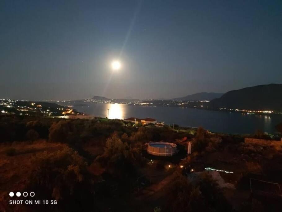 a view of a lake at night with the moon at Όμορφο διαμέρισμα με θέα in Korakiaí