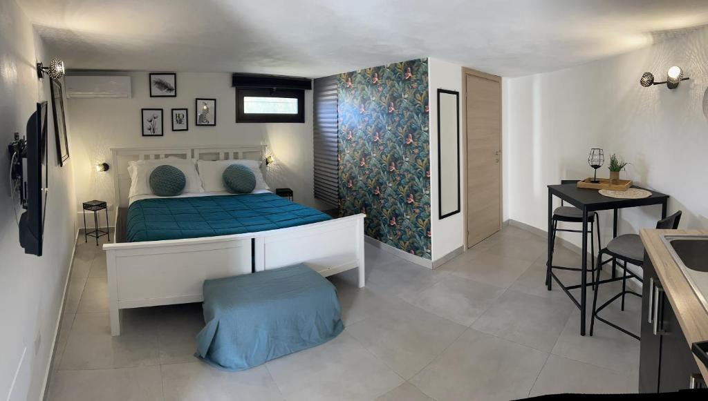 法努薩的住宿－Casa con piscina e vista mare dal giardino，一间卧室配有一张带蓝色床单的床和一张桌子。