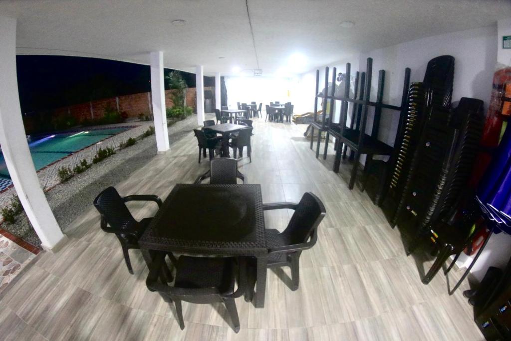 阿卡西亞斯的住宿－BAHIA MALECON，一个带桌椅的用餐室和一个游泳池
