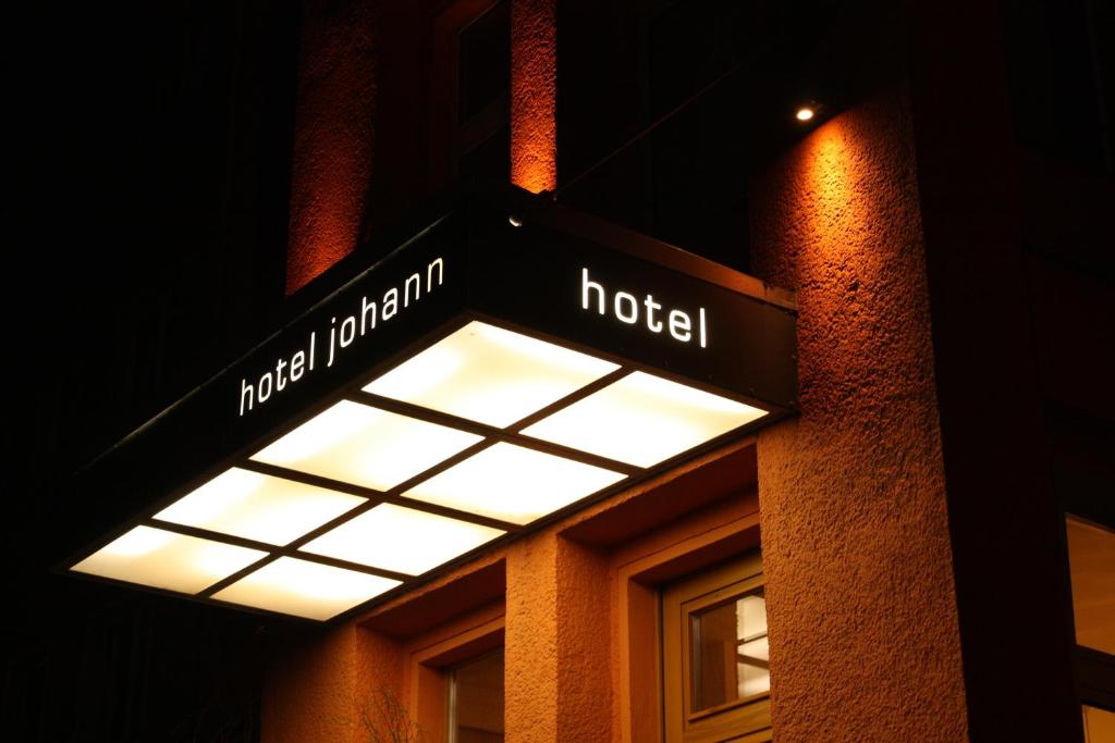 un letrero de la calle para un hotel al lado de un edificio en Hotel Johann en Berlín