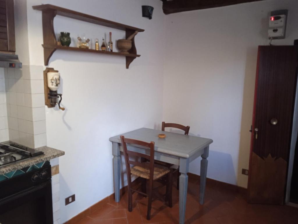 una pequeña cocina con mesa y 2 sillas en La casa di Daisy, en Pitigliano