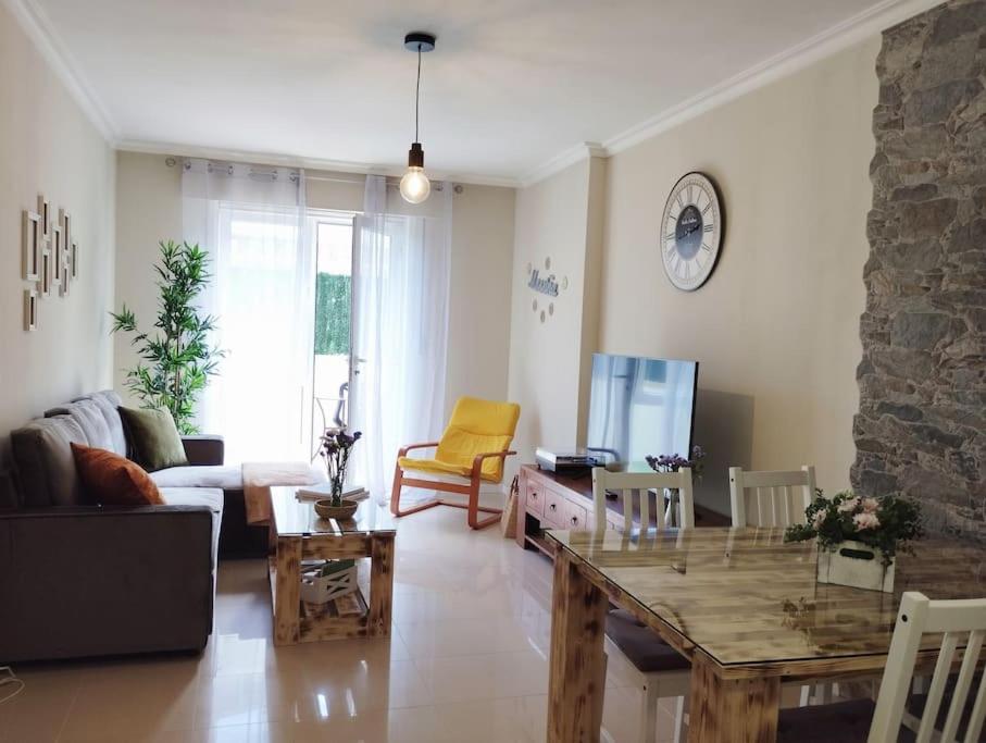 a living room with a table and a couch at Apartamento Morriña in Brion
