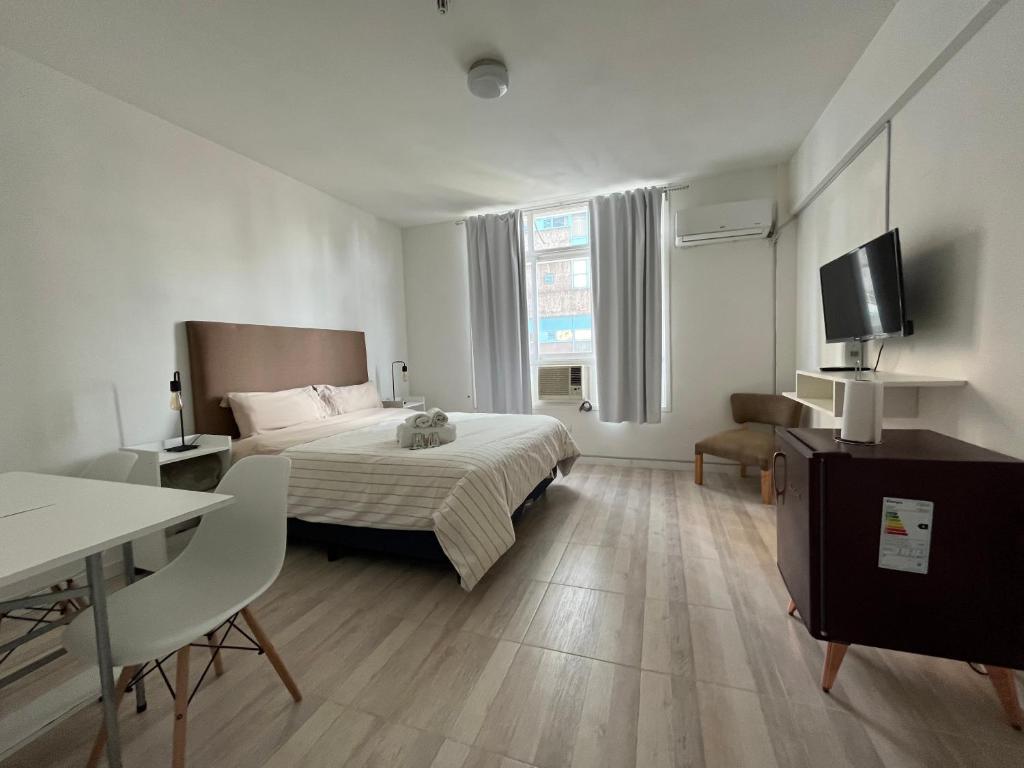 1 dormitorio con 1 cama, escritorio y TV en Liberty Apartment Studio en Buenos Aires