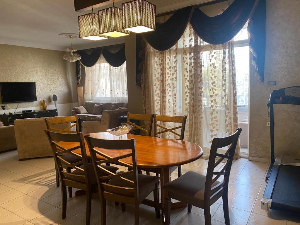 a dining room with a wooden table and chairs at Zagha house in Amman