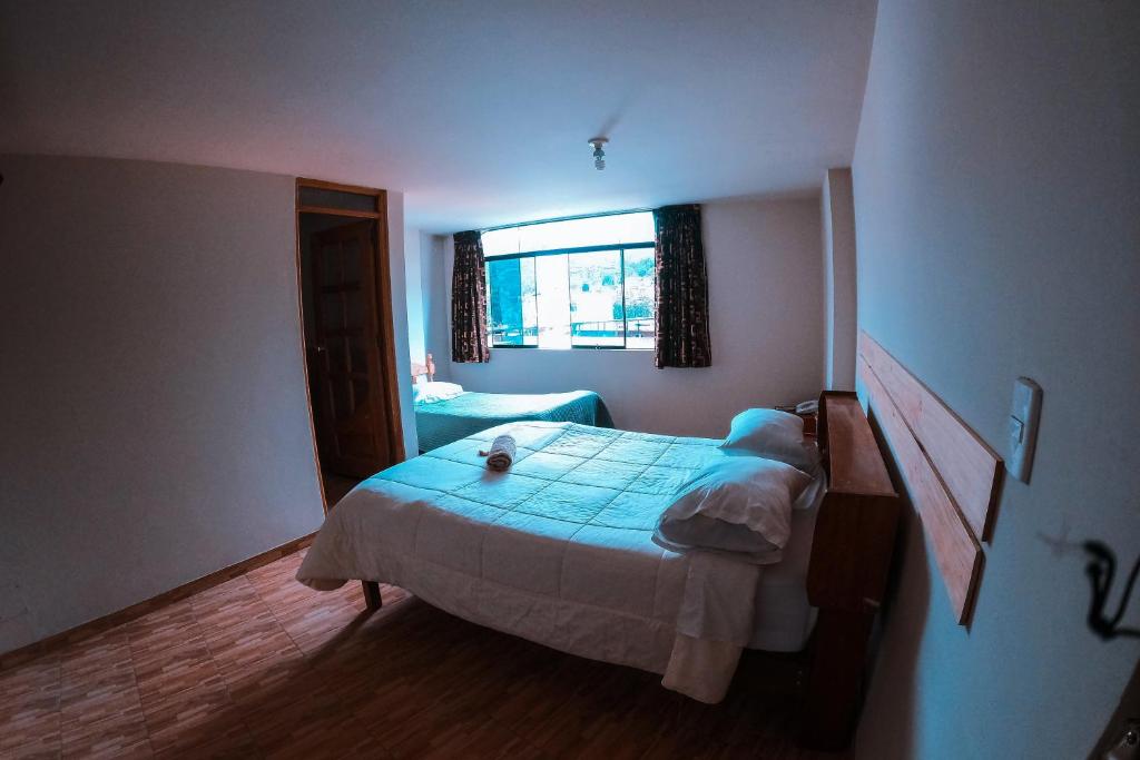 um quarto com uma cama e uma janela em Chacraraju Hostel em Huaraz