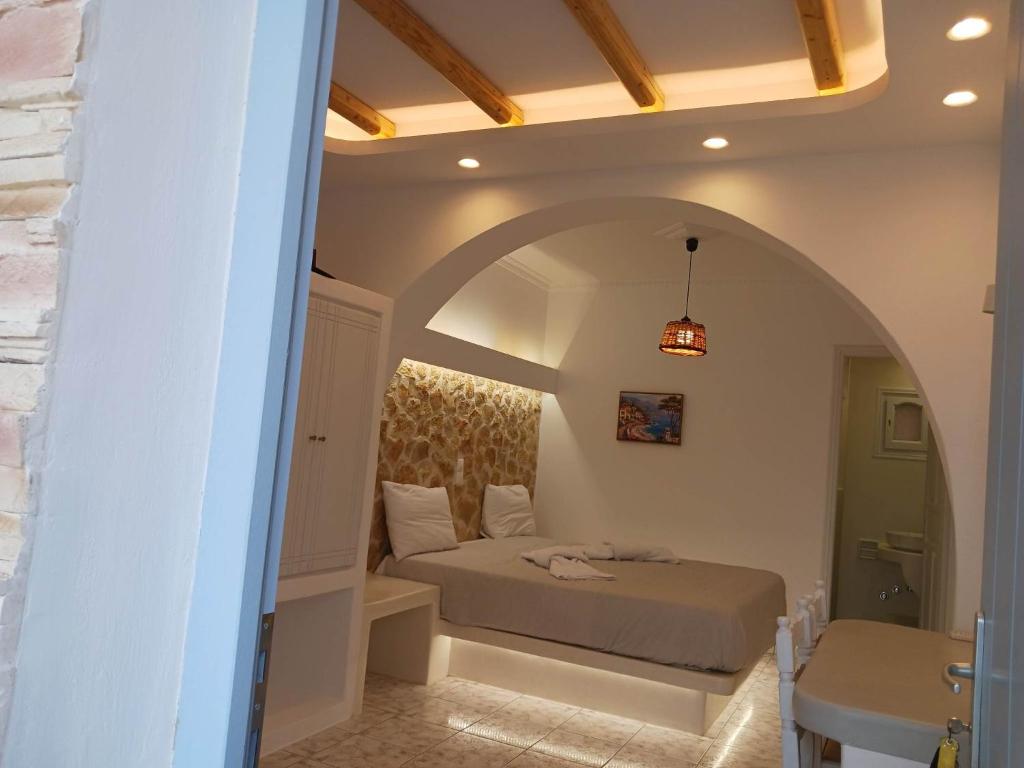 アギオス・プロコピオスにあるAkrogiali Agios Prokopiosのアーチ道のある部屋で、ベッドルーム1室(ベッド1台付)