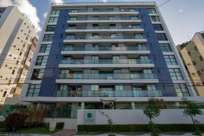 um edifício azul alto com janelas numa cidade em Nomar IV - Belíssimo Apto no Cabo Branco em João Pessoa