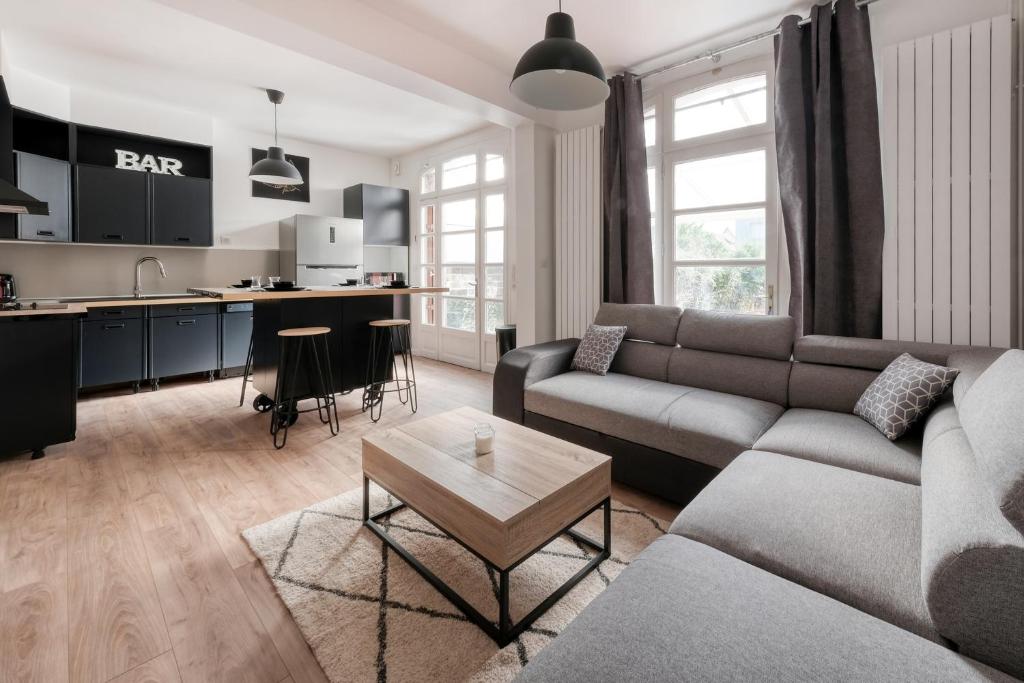 a living room with a couch and a table at Magnifique maison pleine de charme ideale jeux olympiques un kilometre de la gare in Évreux