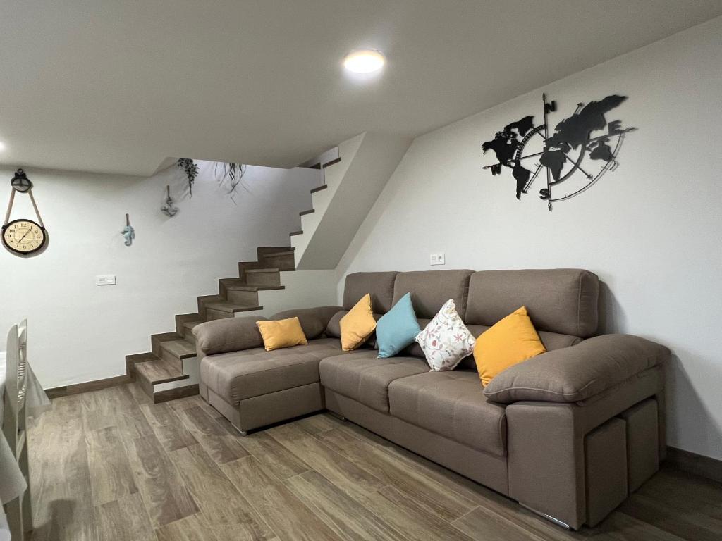 uma sala de estar com um sofá e uma escada em O Cobijo de Elva em Arou