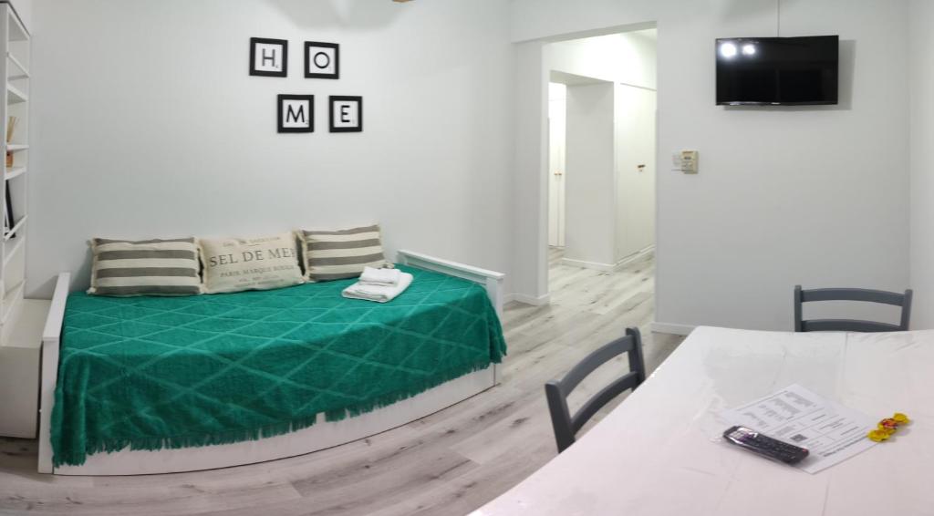 um quarto com uma cama com um cobertor verde em Departamento Del Plaza em Bahía Blanca