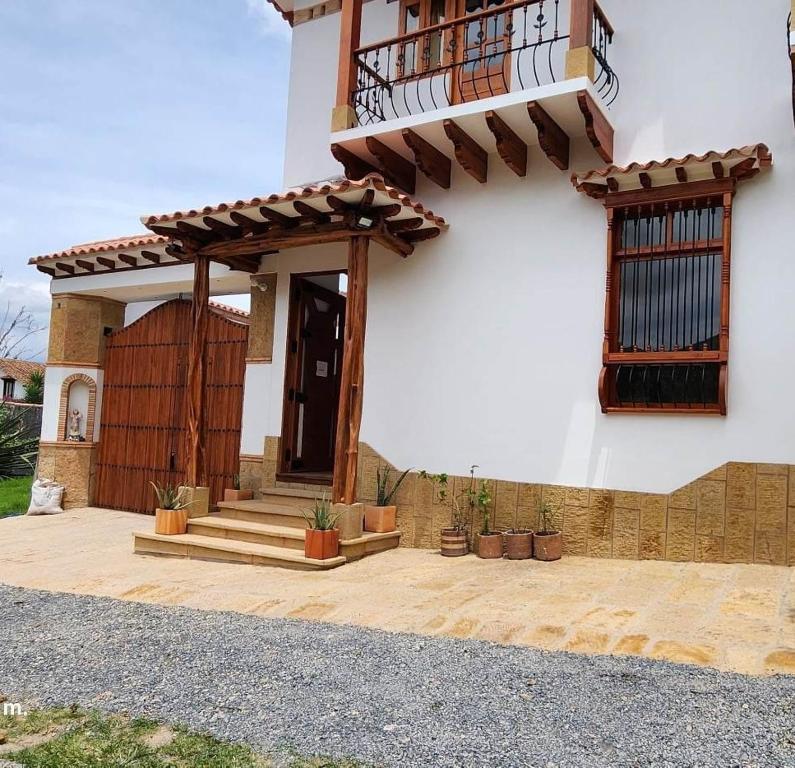 a house with a porch with potted plants at Hotel Villa Javier VDL in Villa de Leyva
